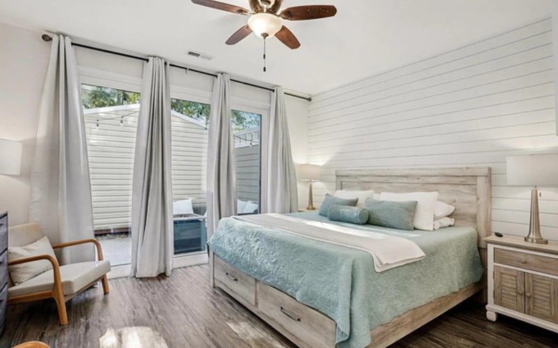Main-level king suite with private patio access — sleep in, you're on beach time